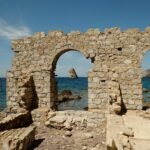 An old stone building sitting on top of a rocky beach