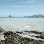 a large body of water sitting next to a rocky shore