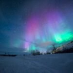 northern lights over snow-capped mountian