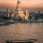 a boat in the water with a large building in the background