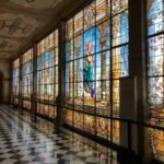 a hallway with a checkered floor and large stained glass windows